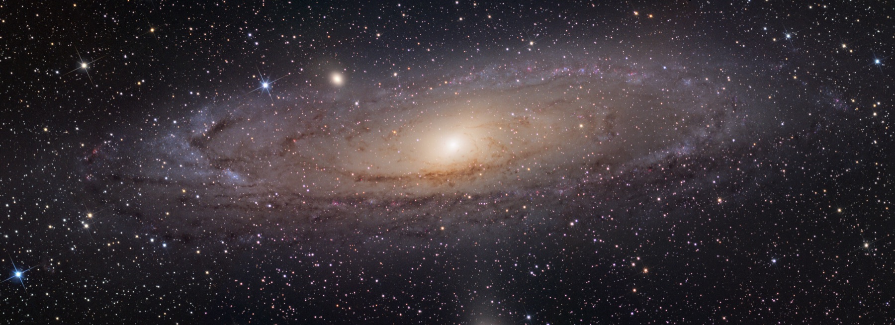 Wide view of the Andromeda Galaxy, the partner in the predicted Andromeda-Milky Way collision, a large tilted spiral with a bright core and dark dust lanes