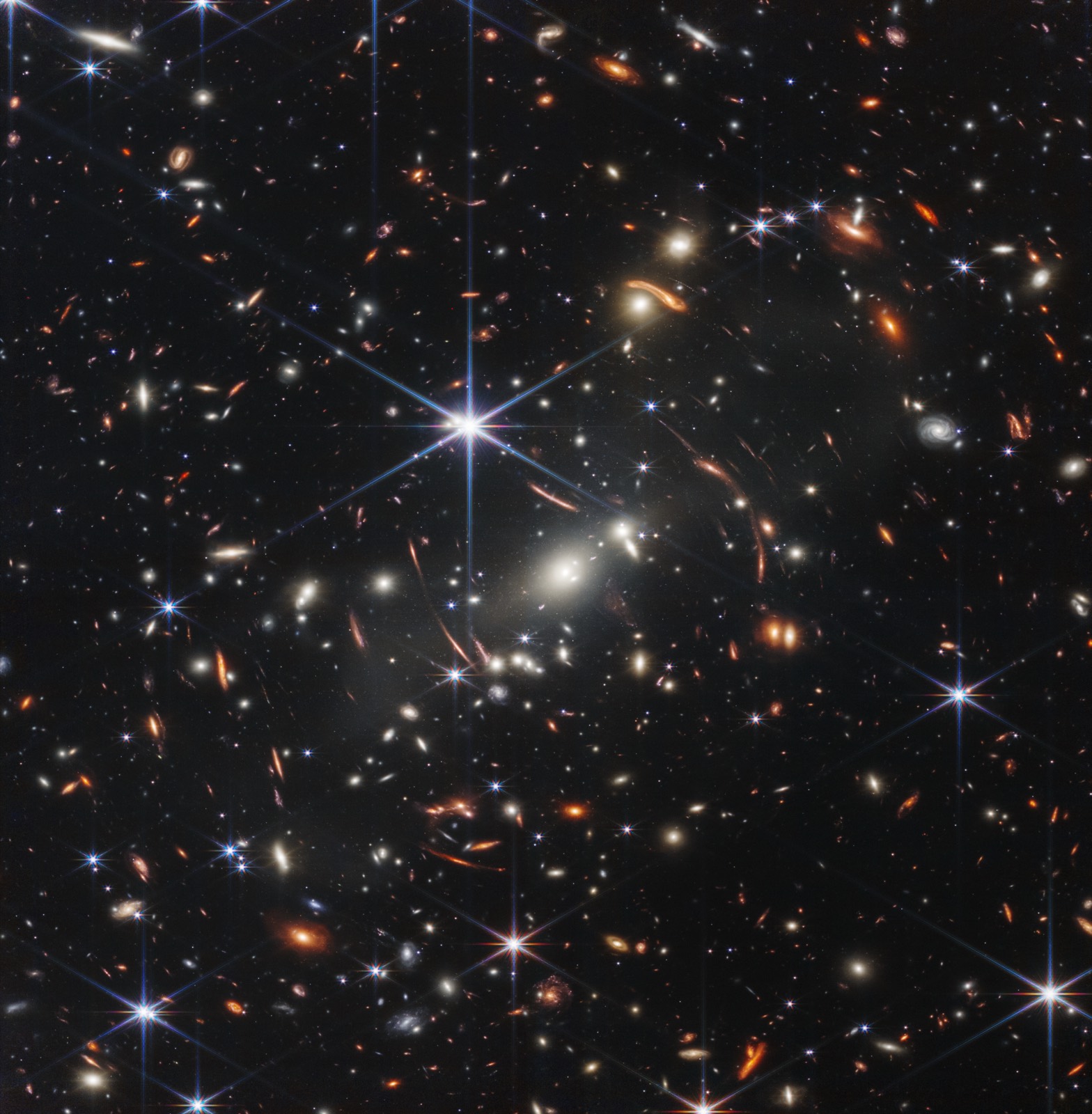 Webb First Deep Field, one of the first JWST discoveries, showing the galaxy cluster SMACS 0723 with stretched arcs of gravitationally lensed background galaxies