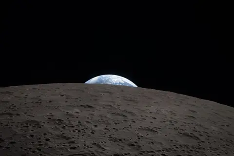 Earth setting behind the cratered far side of the Moon, photographed by the Artemis II crew from the Orion spacecraft.