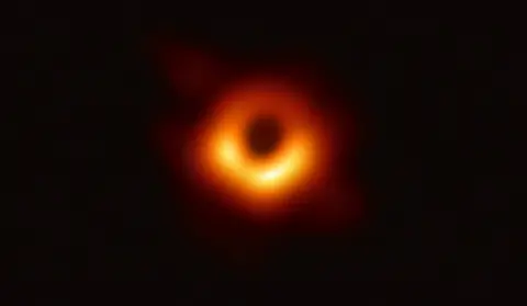 The first image of a black hole: a glowing orange ring of hot gas around the dark shadow of M87*.