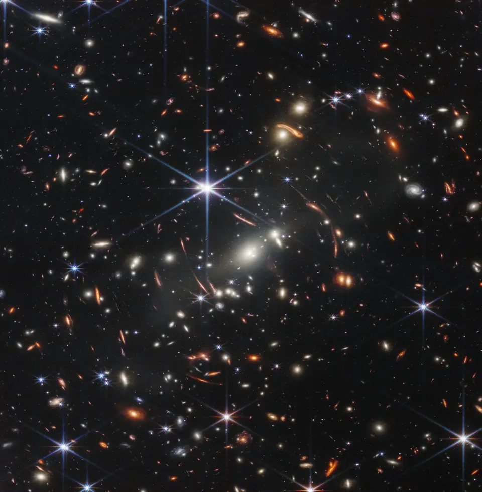 Webb's First Deep Field: thousands of galaxies around the cluster SMACS 0723, some stretched into arcs by gravitational lensing.